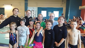 Twelve swimmers splashed to success at the Worland Sugar Beet Dash Dec. 12. Pausing for a photo are teammates (l-r, back row) Anna Fuller, Cindy Baumstarck, Malory Brown, Emerald Jordan, (front) Savannah Prentiss, Kassidy Brimhall, Croix Tryon, Danika Crumrine, William Fuller, Nathan Fuller and Ashtin Prentiss. Not pictured is Azurdey Burton. photo courtesy of Angela Spann