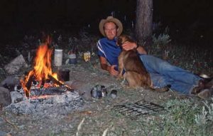 Jeff Pearson relaxes next to a campfire in Sunlight Basin with his companion Bicen during his U.S. Bicentennial cross-state pack trip in 1976. The trip took 95 days to complete. Courtesy photo
