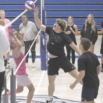 Senior Jett Hessenthaler tips the ball over the net during the homecoming buff puff volleyball tournament Monday night as “coaches” Jenna Hessenthaler and Kaydree Owens look on. David Peck