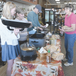 Haley Sorenson (left), her mom, Lea, and husband Cameron Miller serve soup to Jane Undem at Valley Flower and Gifts during the Fall Festival soup walk Saturday in Lovell. The soup fundraiser raised around $2,000 for the Lovell Library. David Peck