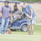 Aden Mayes chips into the green as teammate Carlos Garcia looks on during the Lovell’s Days Golf Tournament Saturday. A rival golfer awaits in the cart behind them. David Peck
